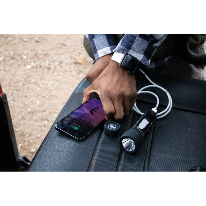 Journey 700 Solar Flashlight Black charging phone on truck bed